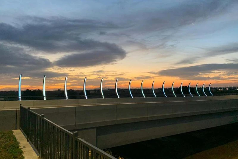 Steel safety barriers along a bridge at sunset