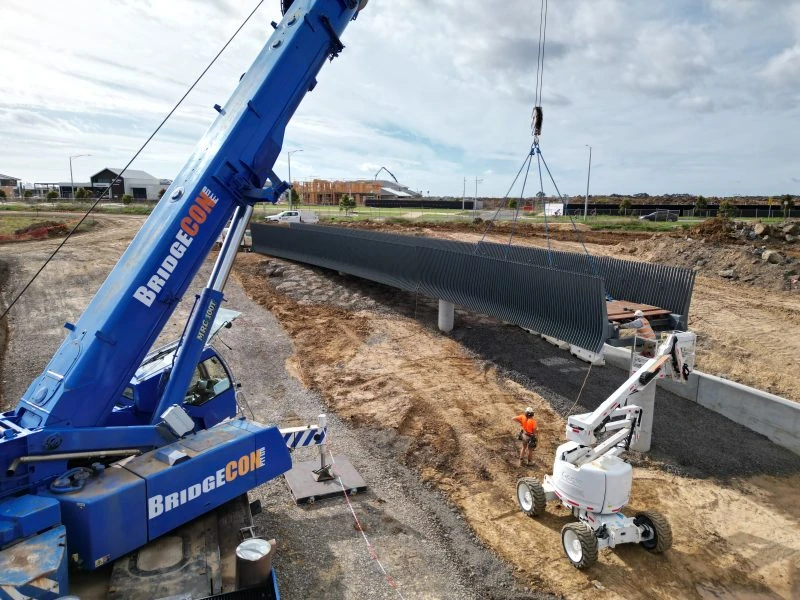 Crane placing a precast beam on a civil construction site